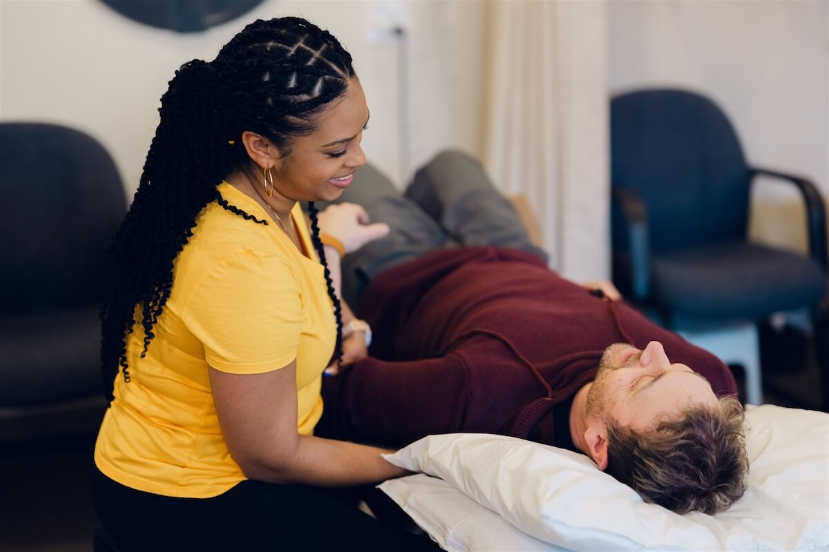 Massage therapist treating a client's neck and shoulders in Osoyoos